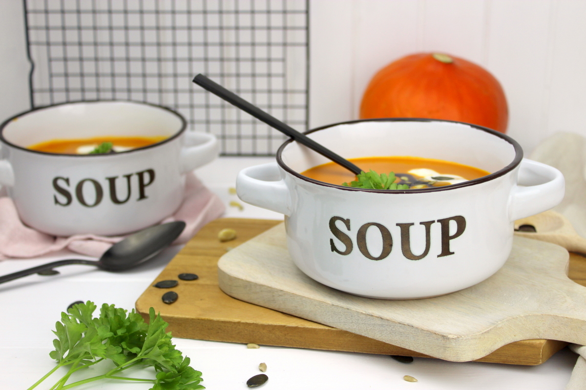 Kürbissuppe mit Hokkaido, Möhren und Kokosmilch serviert mit Petersilie, Kürbiskernen und Kürbisöl